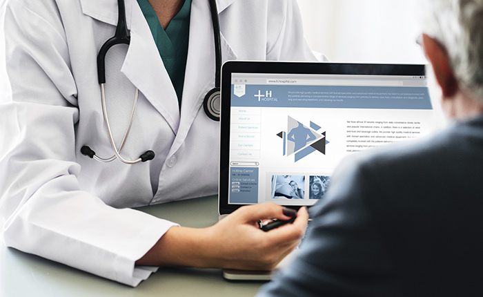 Doctor with open laptop and patient